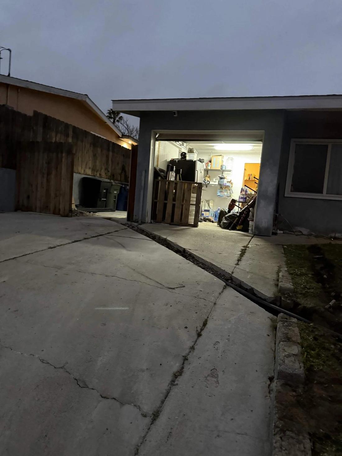 Clean saw-cut trench through a concrete driveway at dusk
