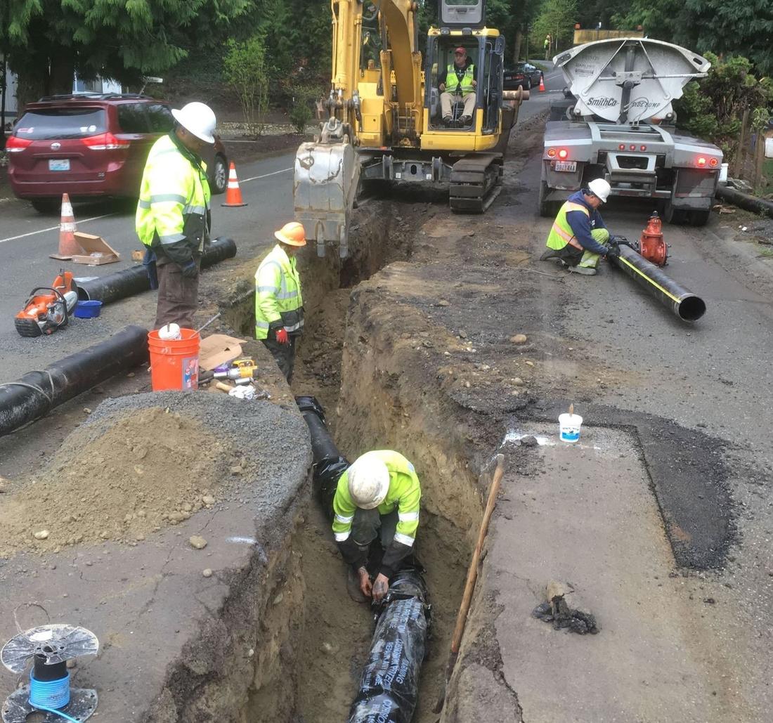 Viper crew in hi-vis working a live street trench with excavator and dump truck