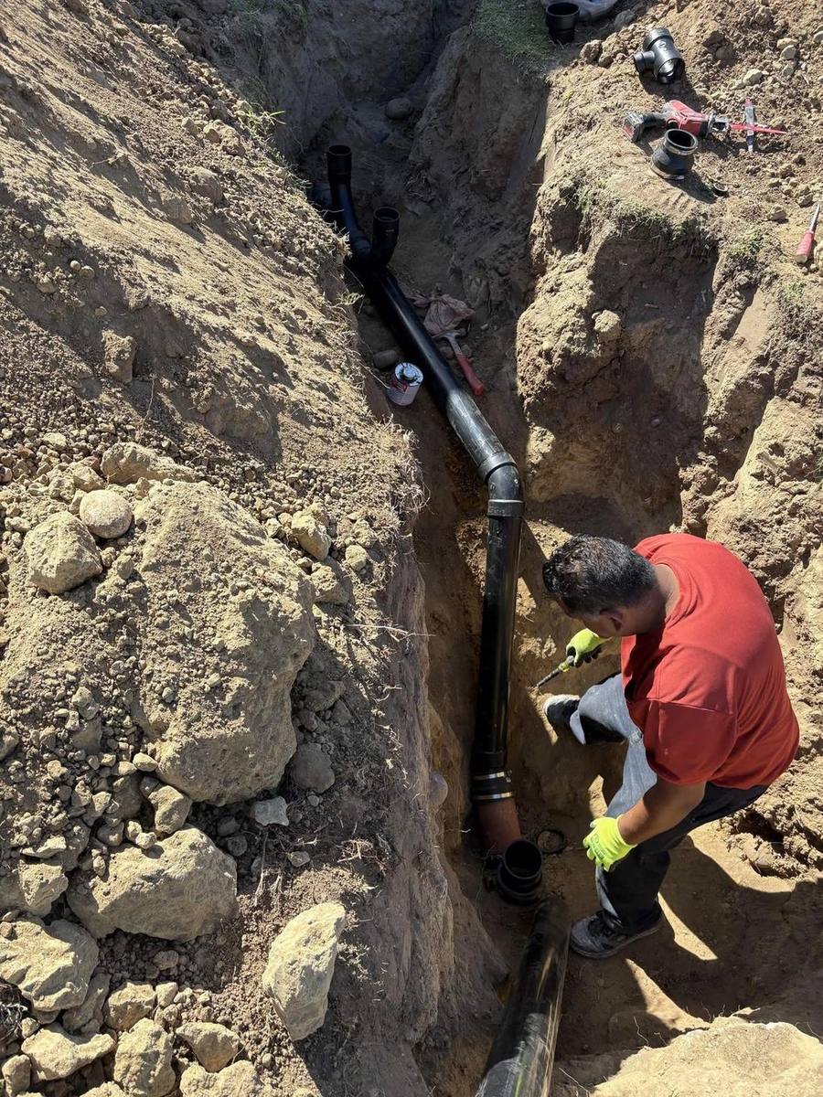 Viper technician setting new ABS pipe in a sewer lateral trench